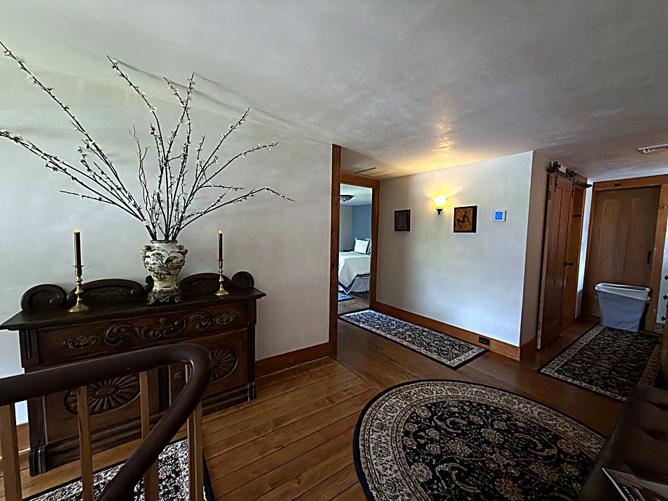 Upstairs bedroom hallway with antique sideboard and candlelight